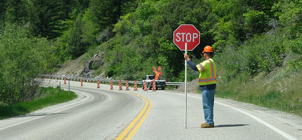 Construction flagger with a stop sign in a road